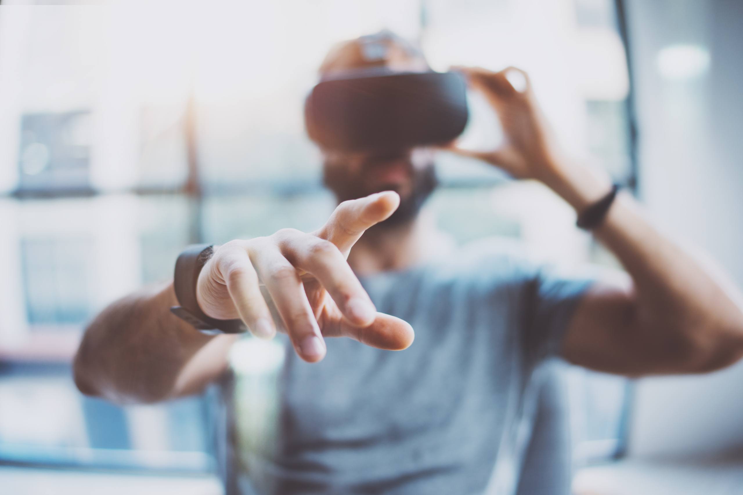 A photo of a man using virtual reality goggles.