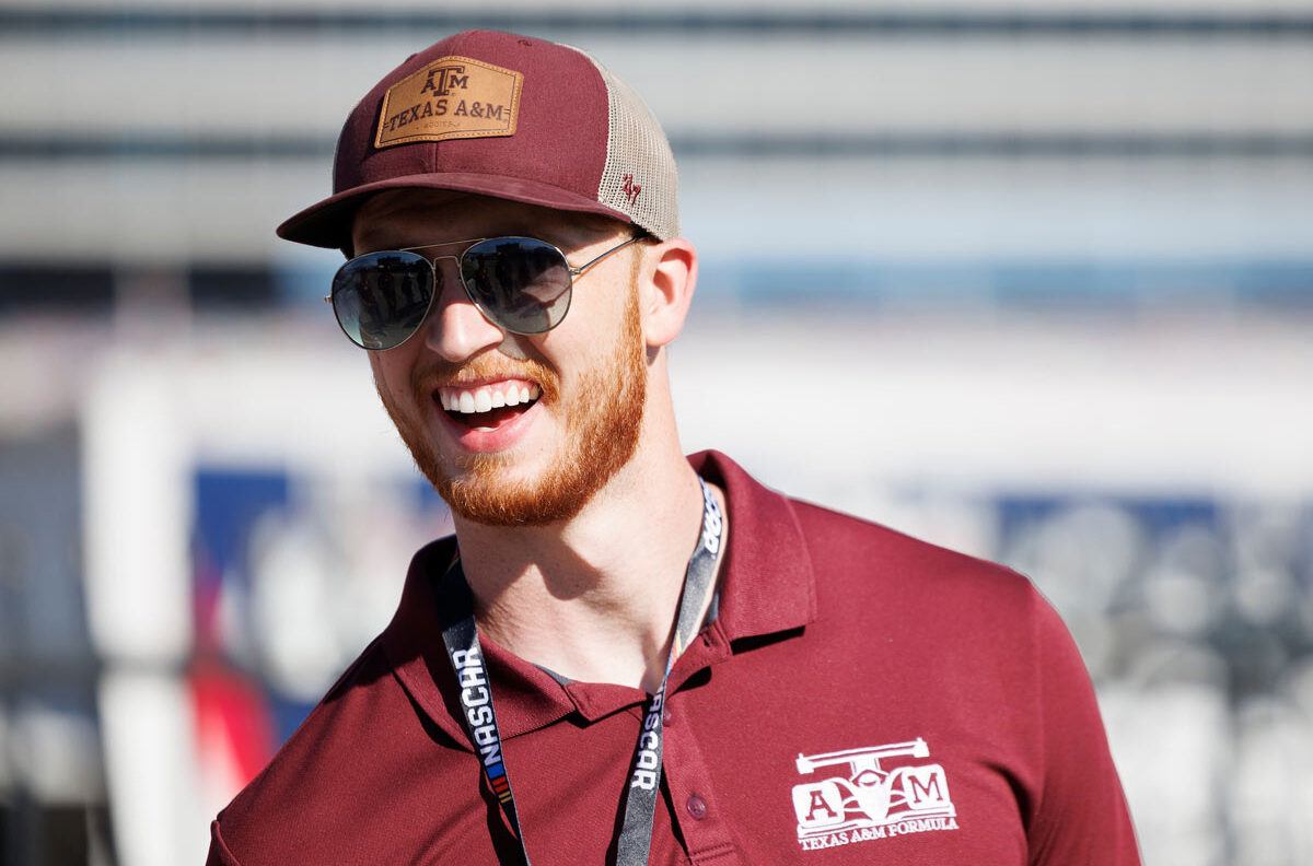 An Aggie wearing a Texas A&M Formula polo laughs joyously