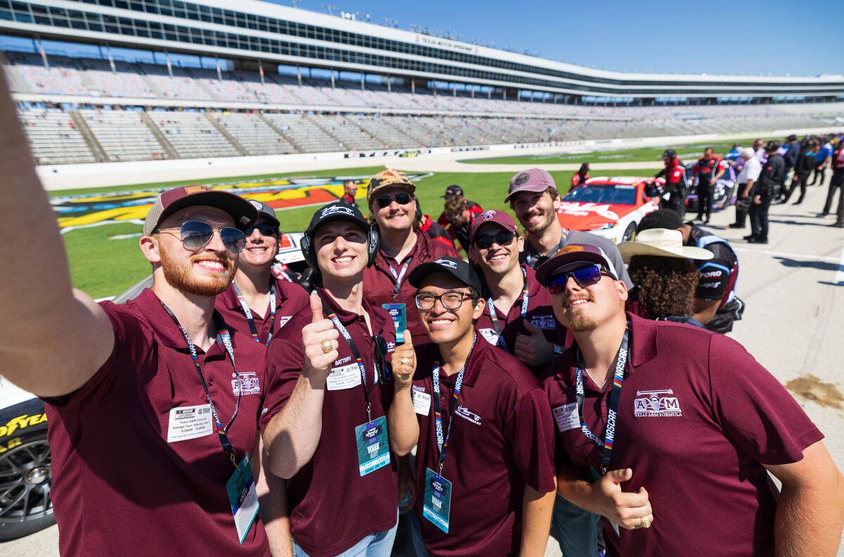 A group of Aggie students pose for a selfie on the track
