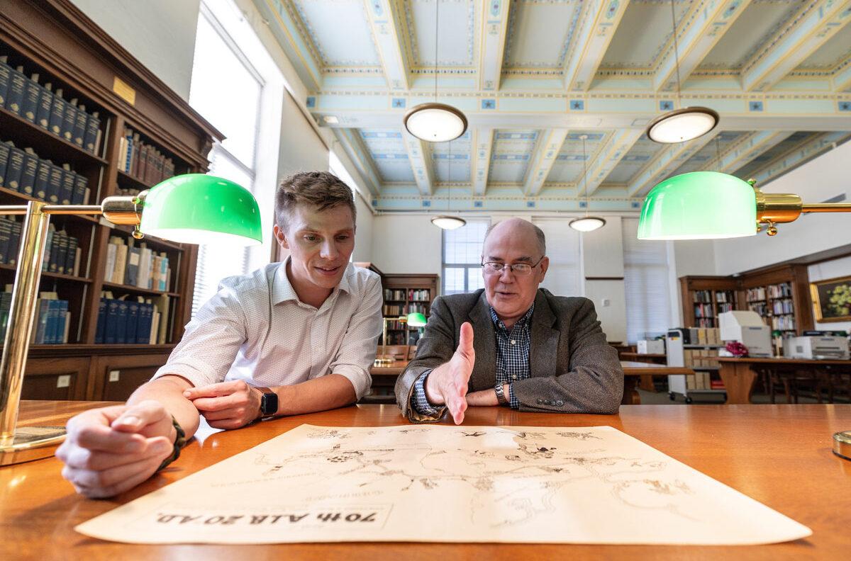 Tristan Krause and a Texas A&M professor discuss an illustrated map
