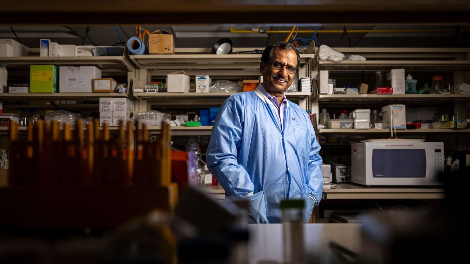 Artistic portrait of Dr. Ashok Shetty wearing lab protective gear