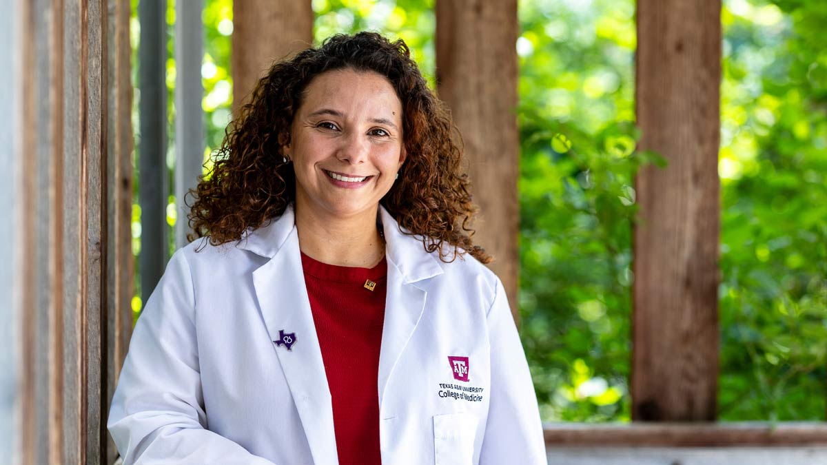 Portrait of Dr. Karienn de Souza wearing a white medical coat