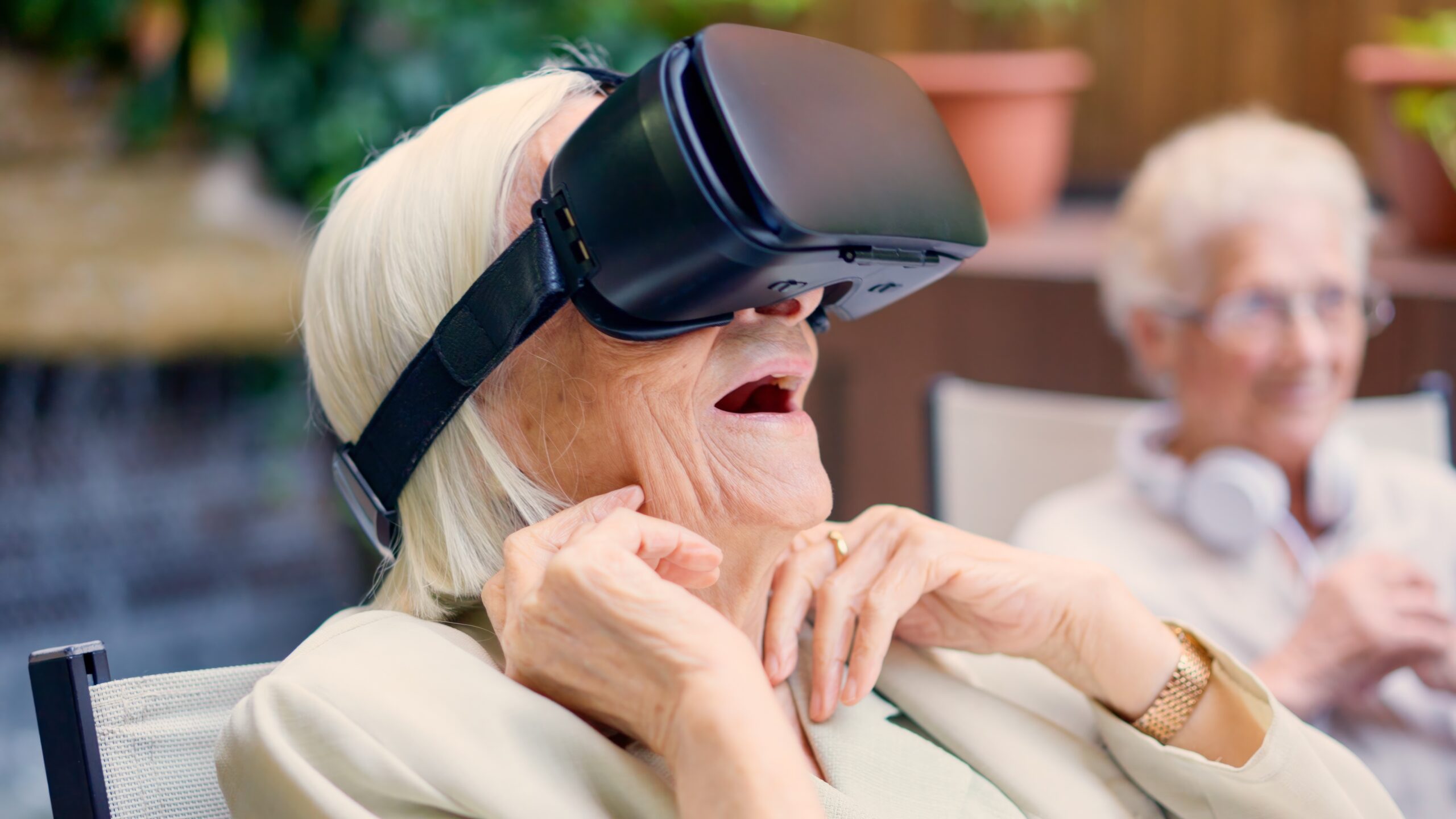 A photo of an elderly woman using virtual reality goggles.