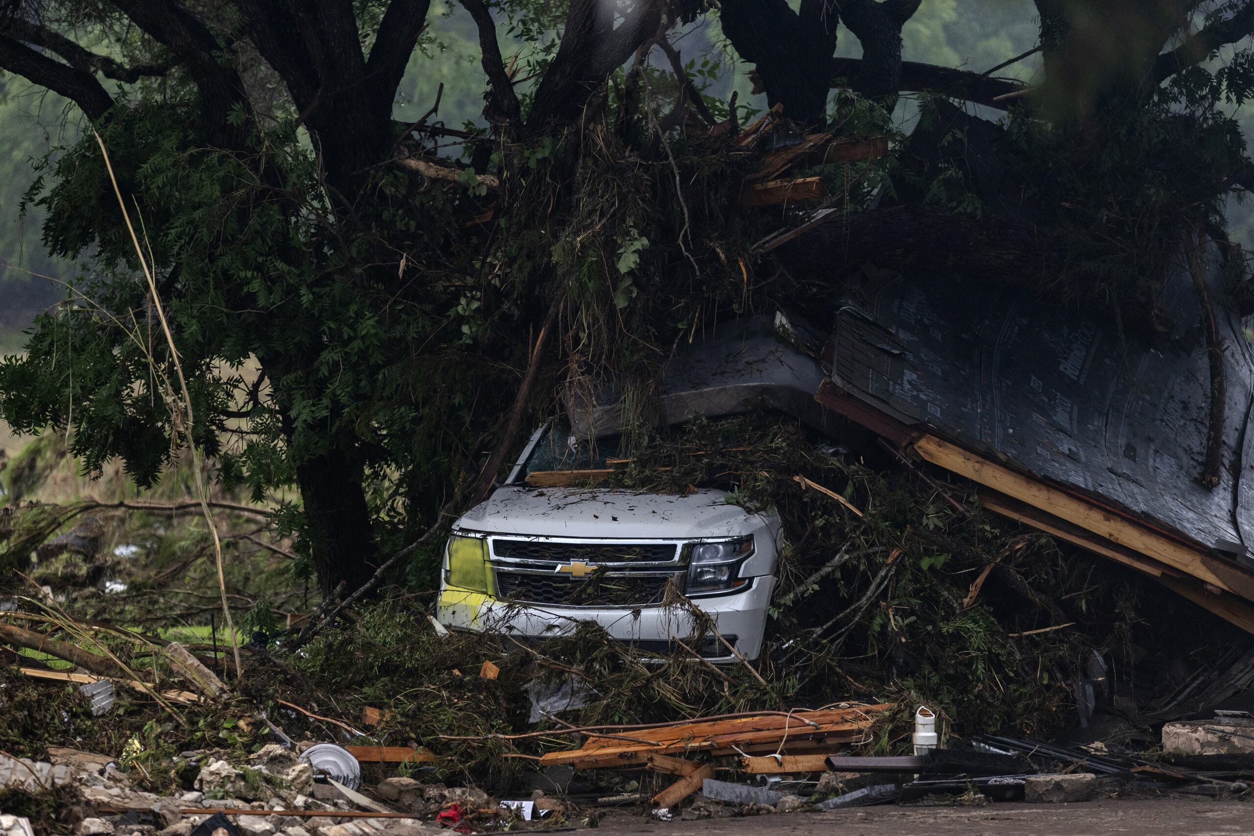 An SUV is covered in debris near Camp Mystic on July 6, 2025 in Hunt, Texas.
