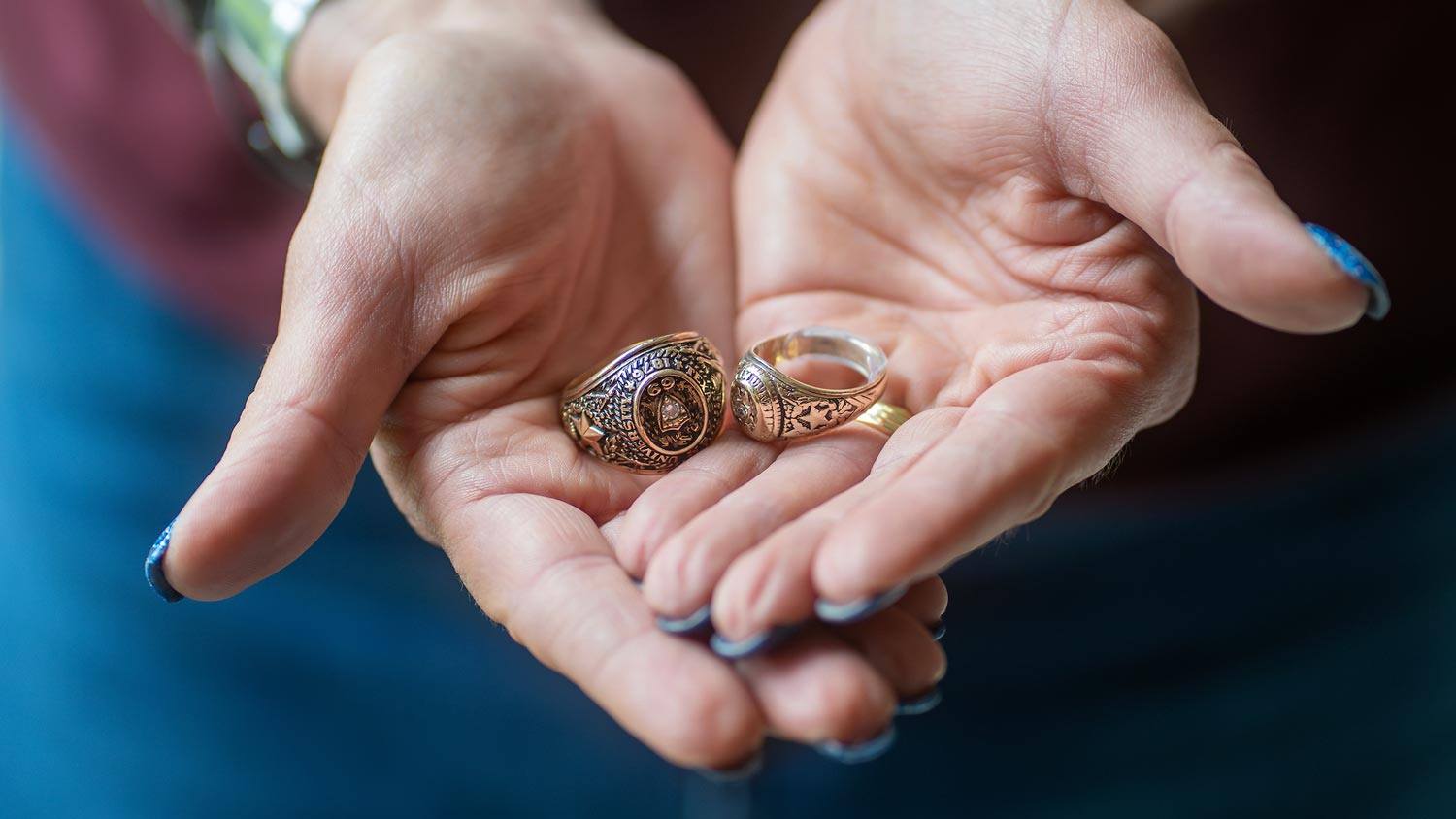 Karoni Forrester holds her and her father's Aggie rings in her hands