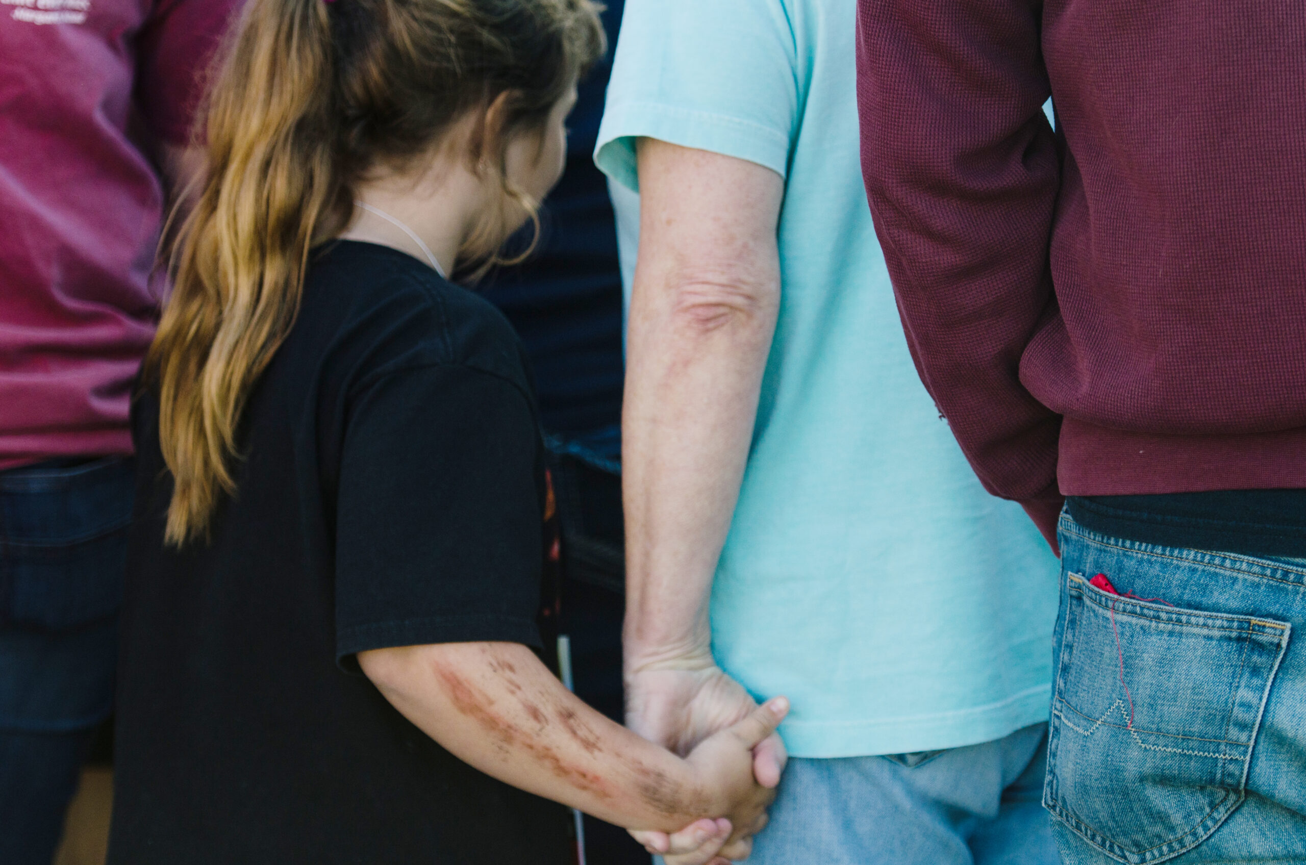 A photo of a girl holding hands with someone in a crowd of people.
