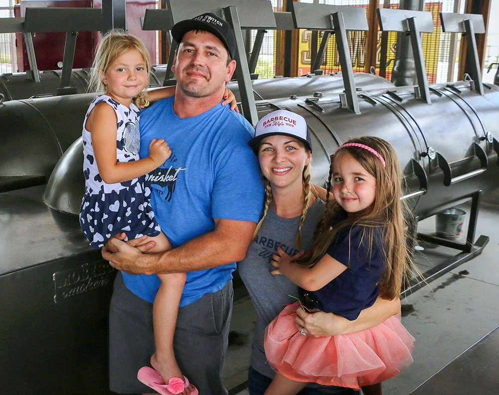 Stiles and his family in front of his barbecue grills and smokers