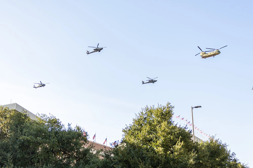 Four military helicopters fly over Kyle Field
