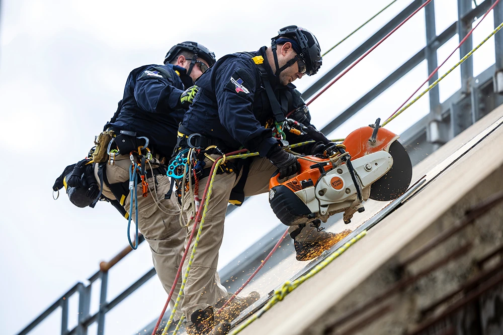 Task Force 1 members use construction equipment when rappelling from a building