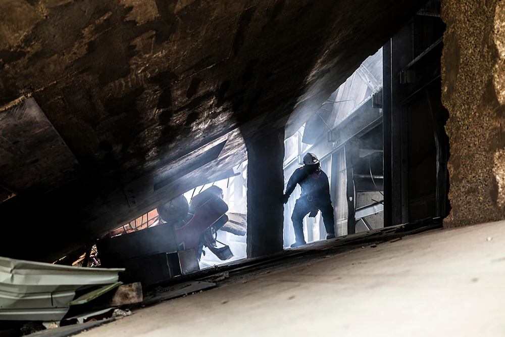 Task Force 1 member exploring a shadowed part of Disaster City