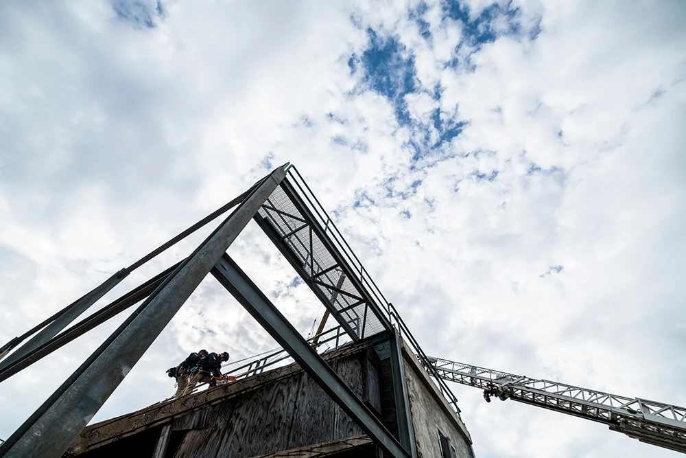 Participants scale a building frame on Disaster Day