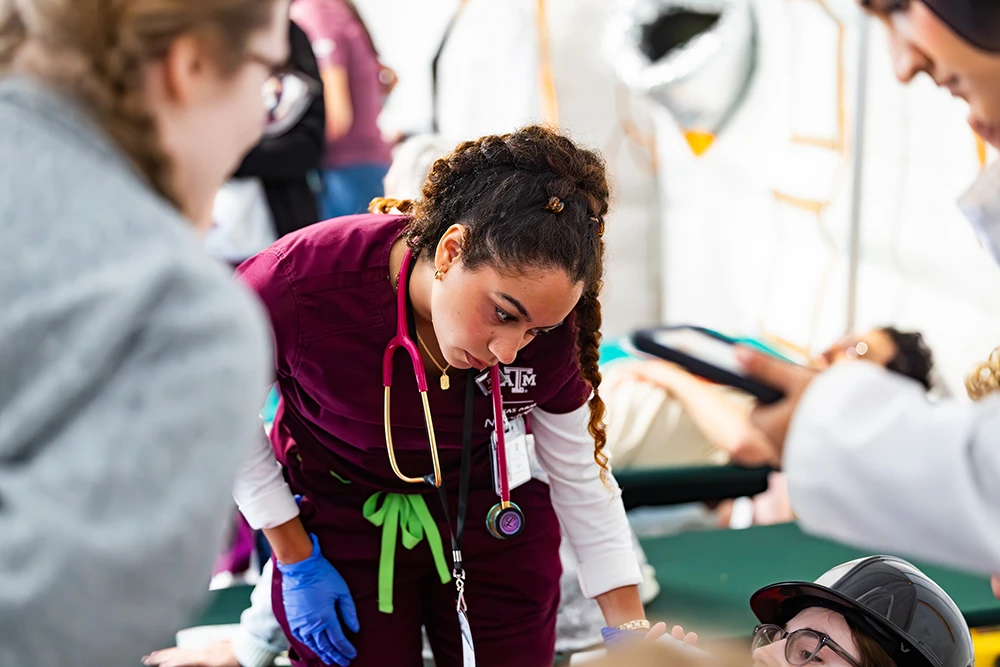 Nursing student with a stethoscope examines a Disaster Day participant