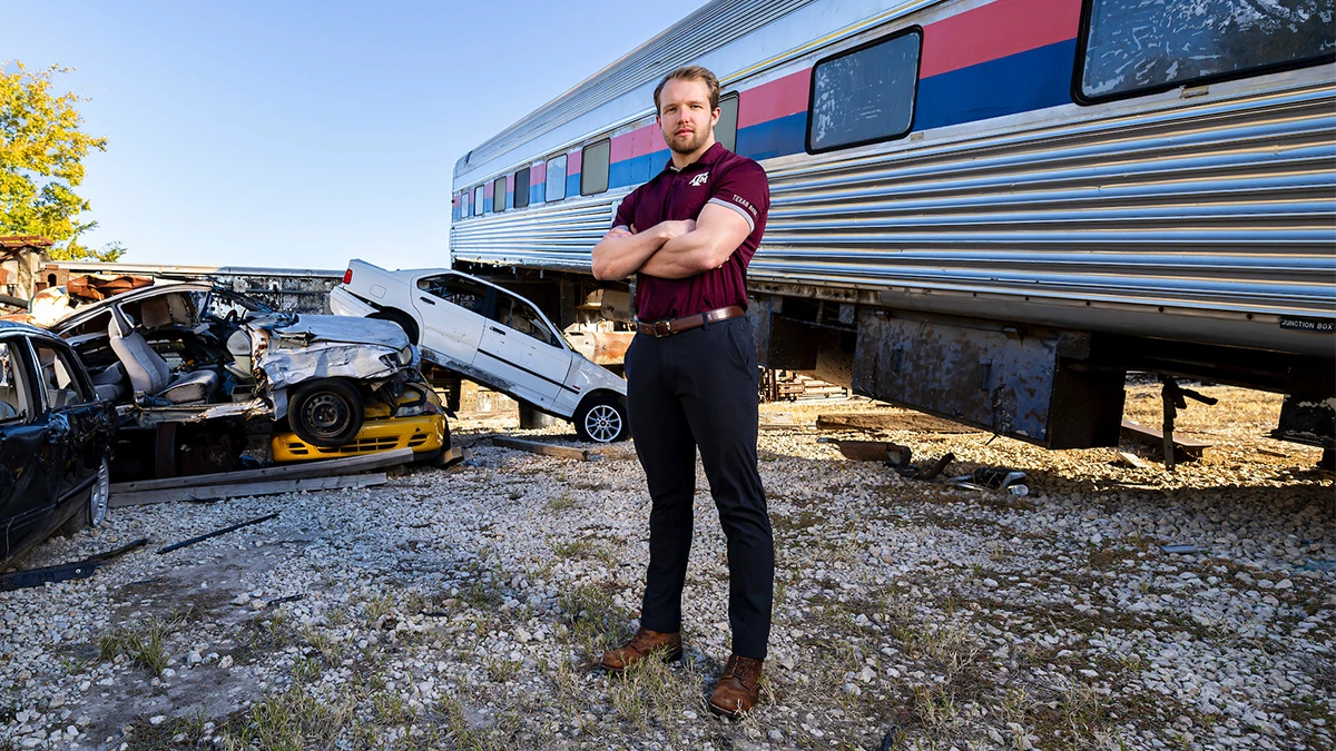 Portrait of Tyler Watson in front of a derailed train and crashed cars