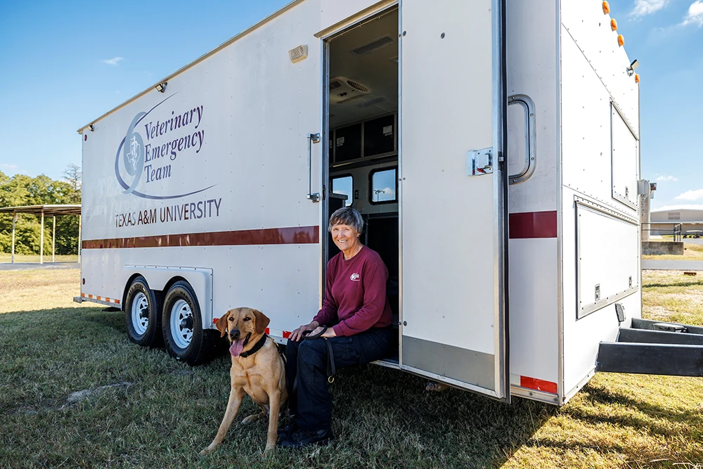 Dr. Deb Zoran sitting in the Vet Emergency Team trailer with a dog