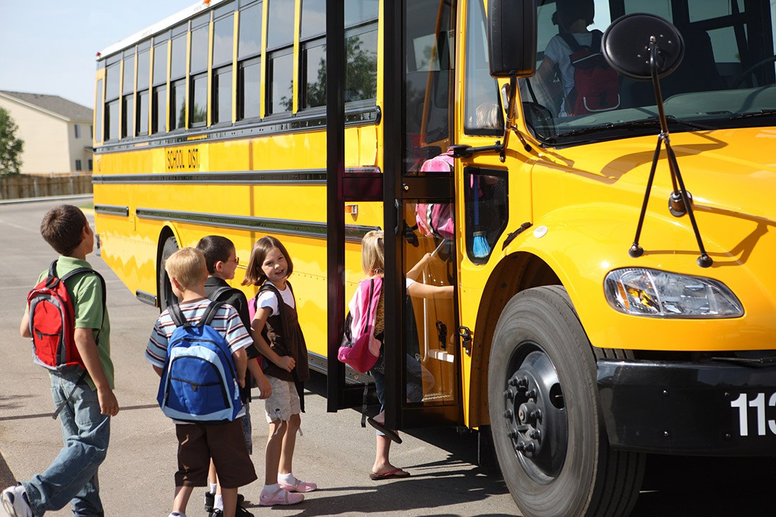 children getting on a school bus