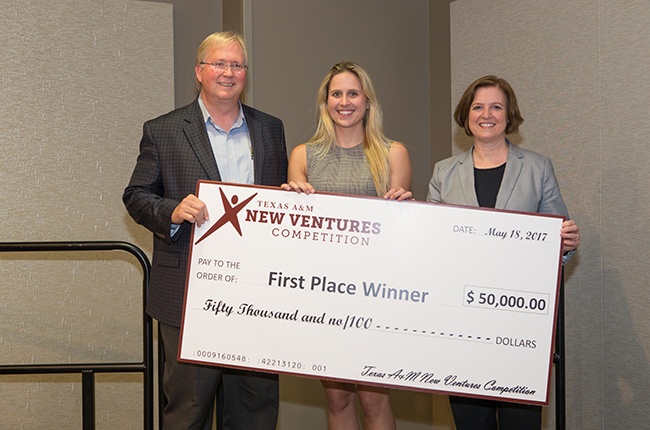 Man and two women pose with giant first-place check