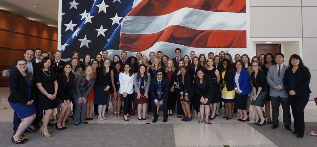 Students pose in front of American flag