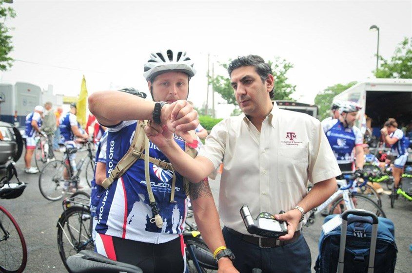 Scientist fitting watch on cyclist