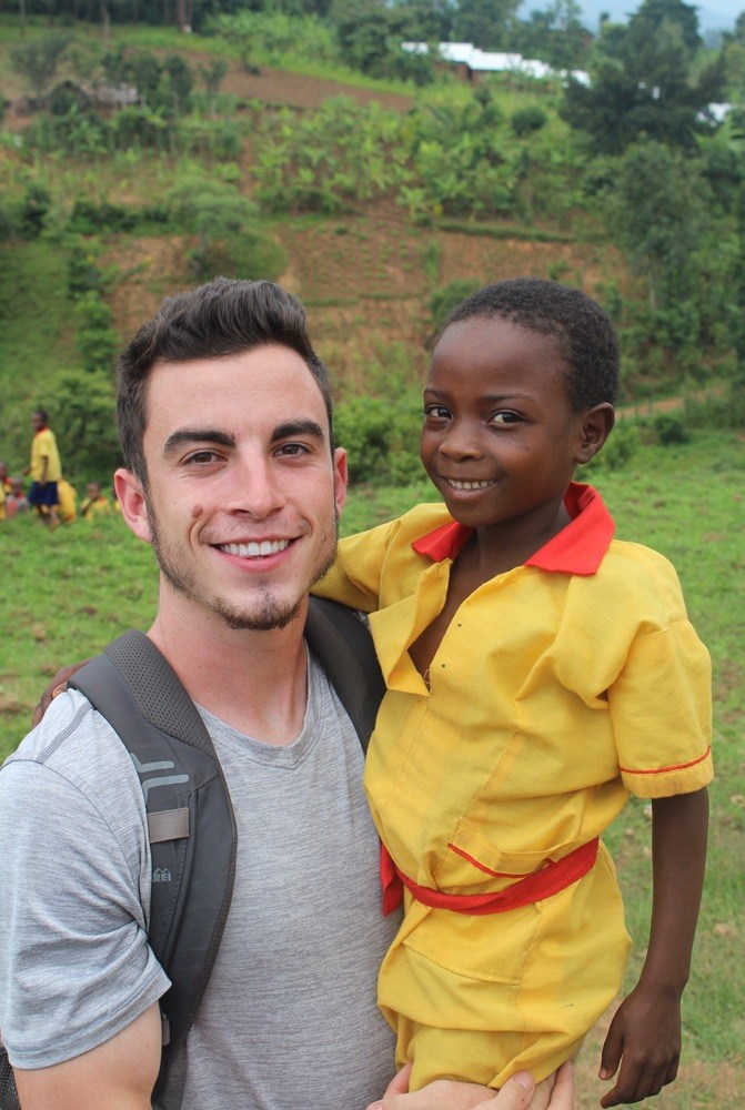 Quinn poses with Ugandan child
