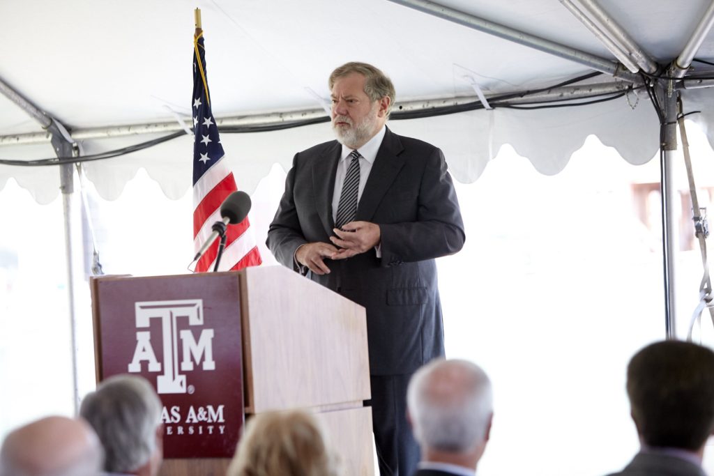 Man presenting at podium in tent