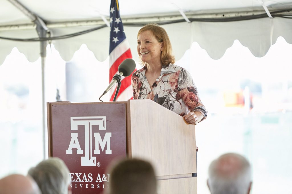 Woman presenting at podium in tent