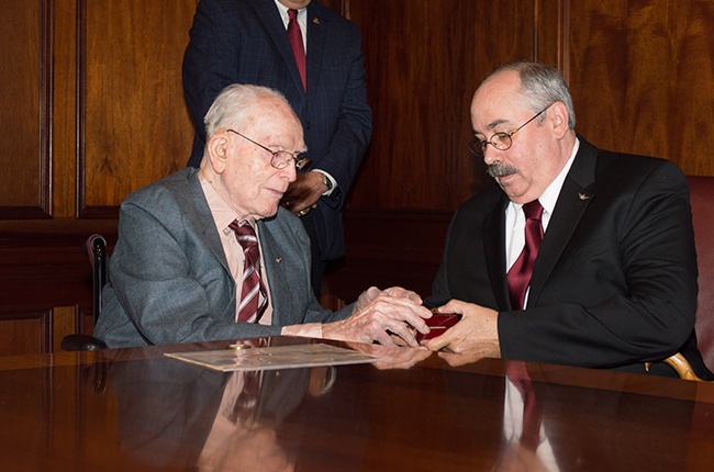 Old man presents ring to Deiss