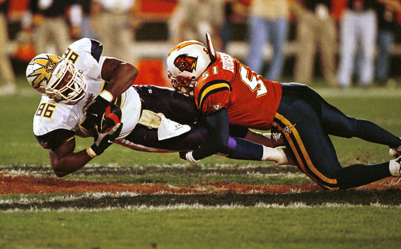 Ed Smith #86 of the Birmingham Bolts is pulled down by Orlando Rage linebacker James Burgess #51 following a first half reception during a first half reception in the Bolts v Rage game at the Florida Citrus Bowl in Orlando, Florida.