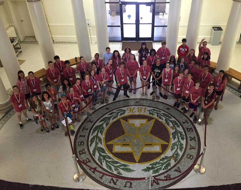 P4C summer camp poses around the star in the academic building