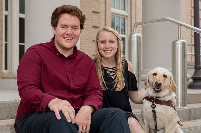 Scott and Hillary Oswald posing with Alika, Hillary's guide dog