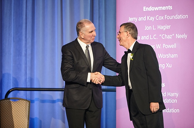 Texas A&M University President Michael K. Young (left) welcomes Richard A. Dixon as a Hagler Institute fellow.
