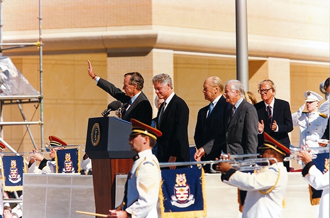 George H. W. Bush waving at a podium