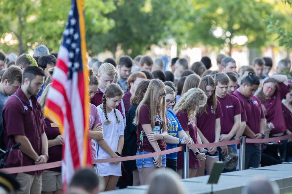 Students honoring a moment of silence at the Reveille VIII gravesite