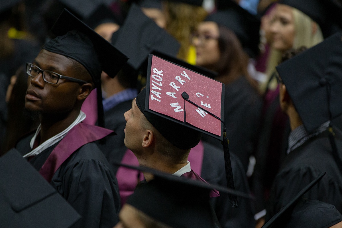 Jonathan sitting among his fellow Aggie graduates